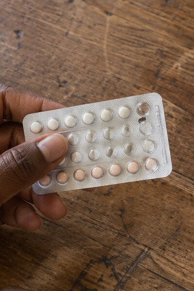 Hands holding a blister pack of birth control pills